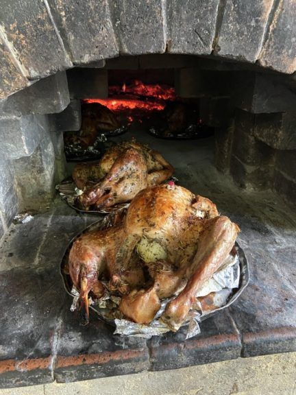 Turkeys roasting on an open fire