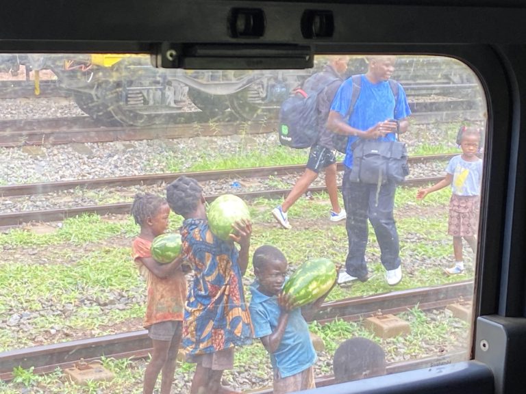 Kids selling watermelons from the tracks