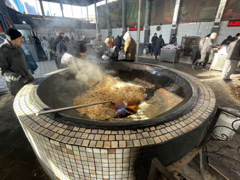 Making plov in huge, wood burning vats. This is a whole warehouse-sized kitchen devoted to plov